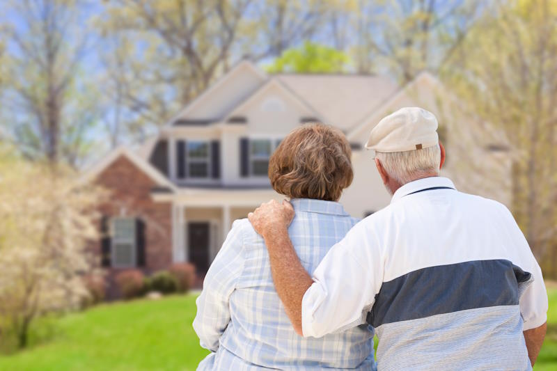 Couple de seniors regardant leur maison. Bénéficiaires d'une aide au logement ?