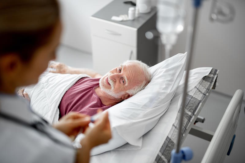 Patient âgé couché dans un lit de sa chambre en USLD