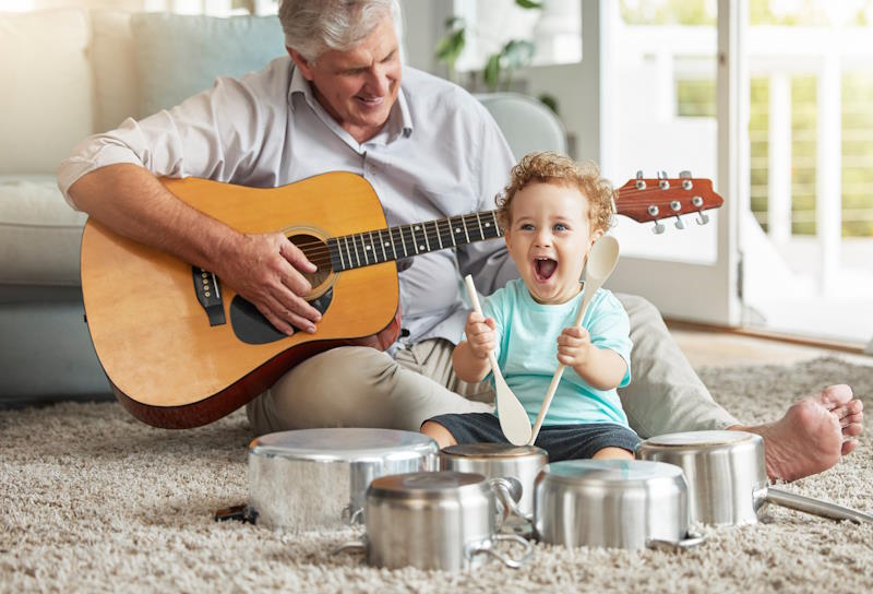 Senior jouant de la guitare avec son petit-fils