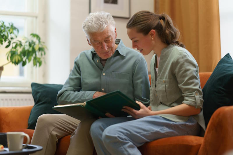 Etudiant et résident d'Ehpad assis sur un canapé partageant un bon moment en colocation intergénérationnelle