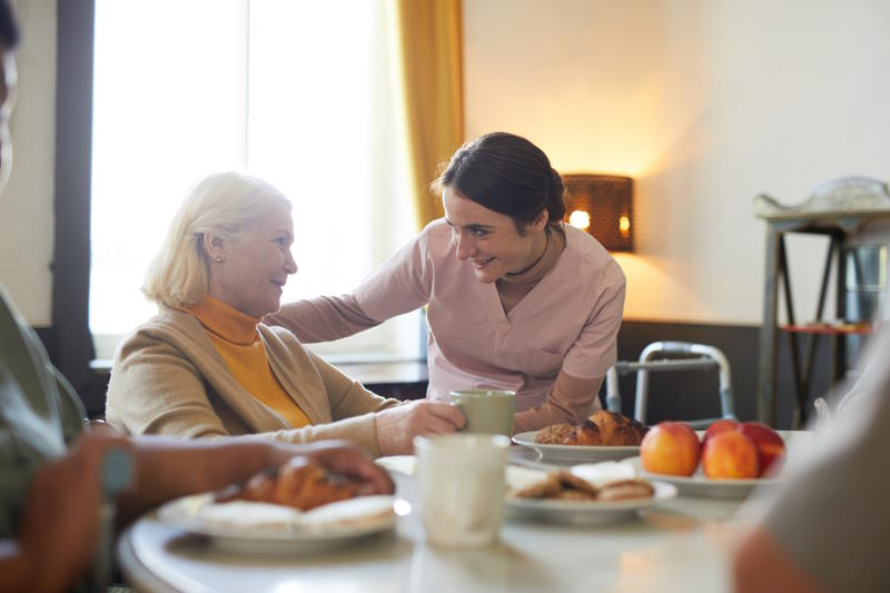 Une personne âgée mangeant un repas à l'accueil de jour Alzheimer