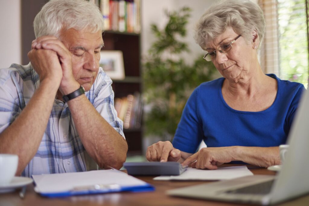 couple de seniors calculant leurs dépenses pour leurs prochaines vacances