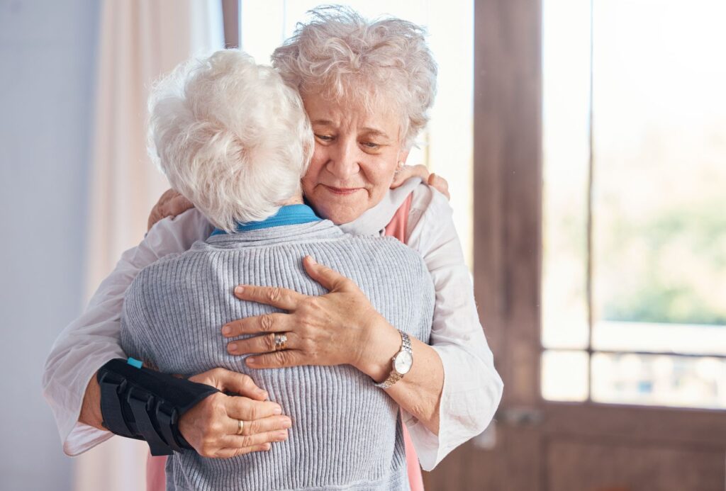 Maman âgée atteinte d'Alzheimer et sa fille aidante s'enlacent