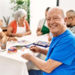 Homme âgé souriant au cours d'une activités à l'accueil de jour Alzheimer