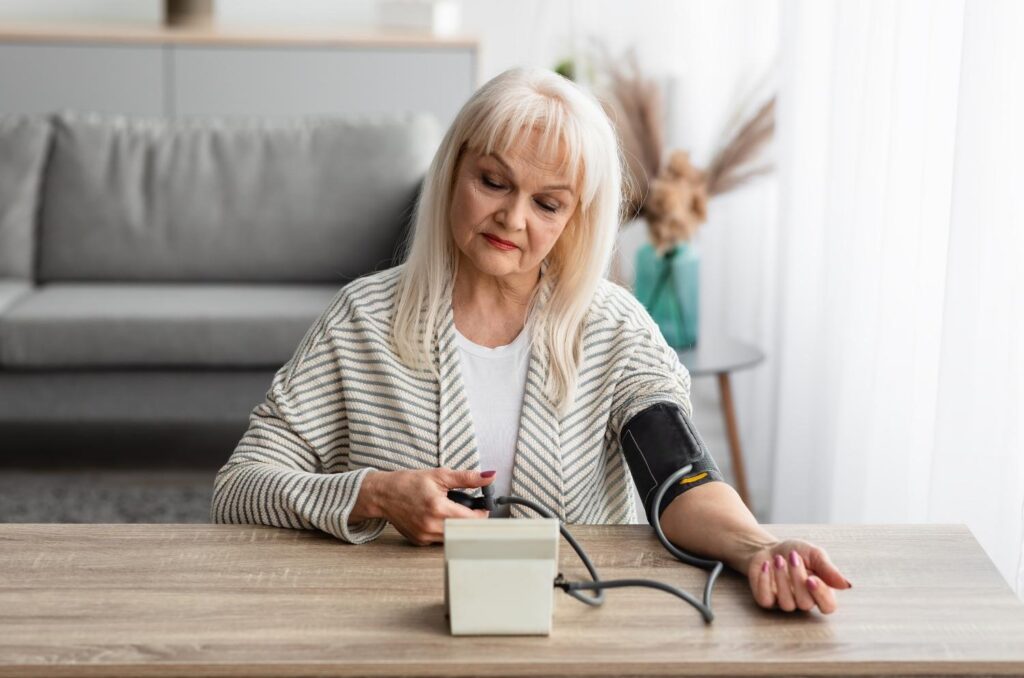 femme senior de 70 ans mesurant sa tension à domicile