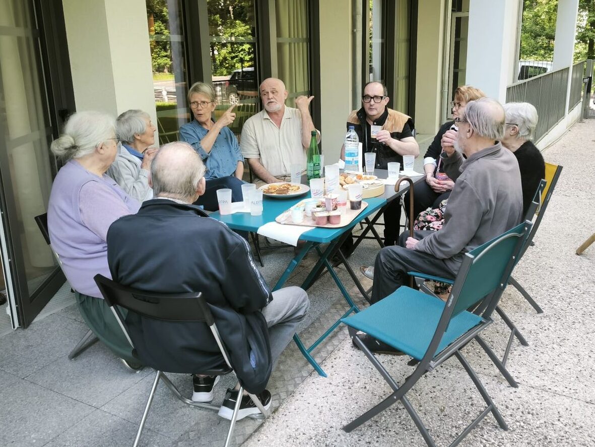 Groupe de seniors de la résidence profitant d'un déjeuner en extérieur