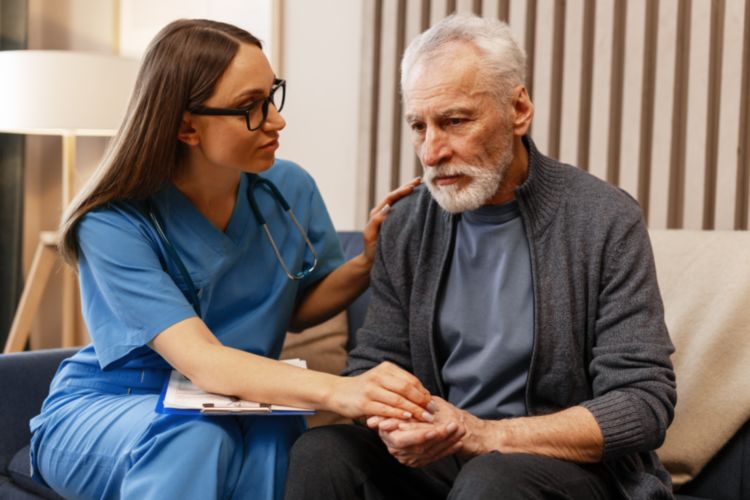 Aide-soignante soutenant un senior déprimé, dans une maison de repos pour dépression