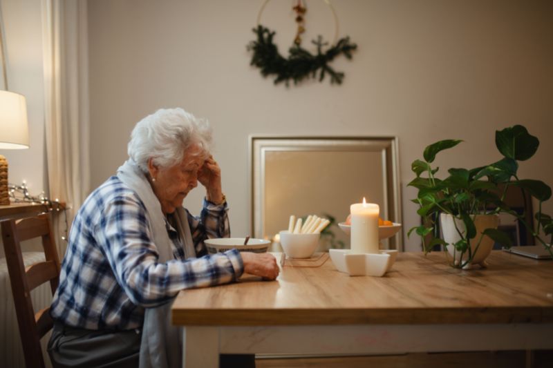 Personne âgée assise à table et isolée à domicile